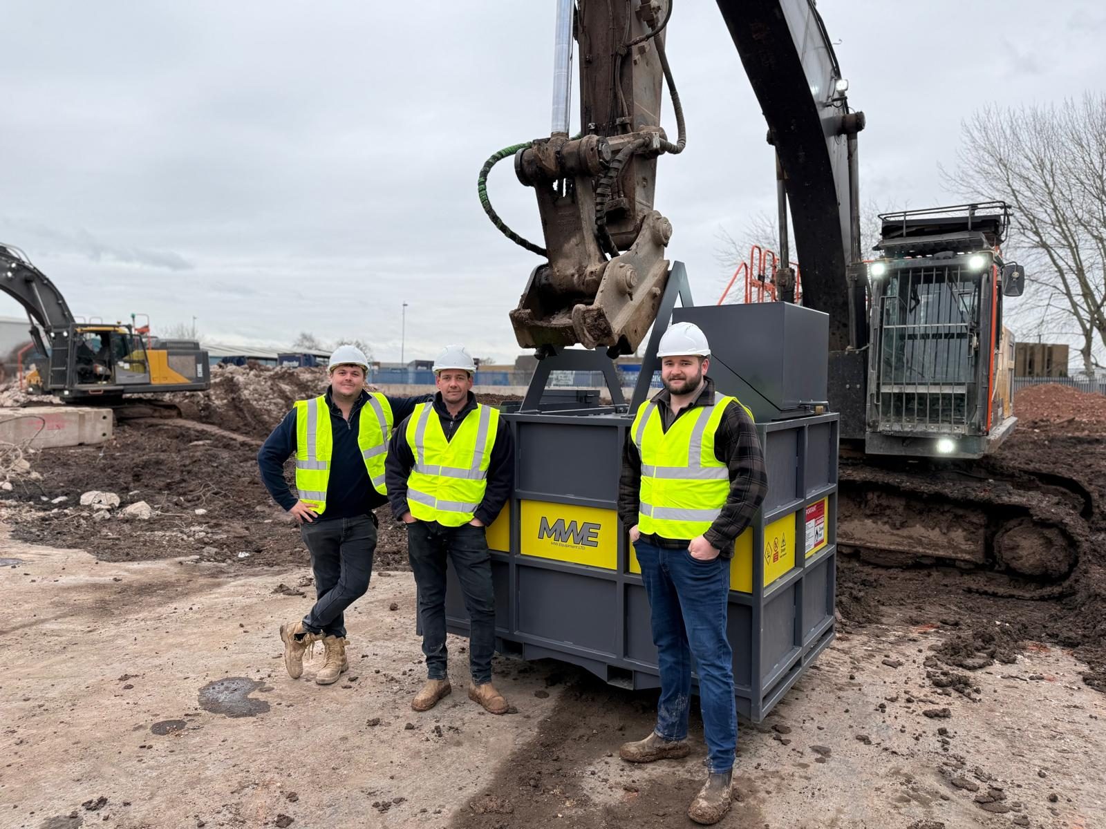 The three founders of MW Equipment LTD in hi-vis on site beside an MWE FuelBag and demolition excavator